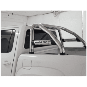White pickup truck in a garage with a chrome tubular roll bar and an Amarok badge in the bed area