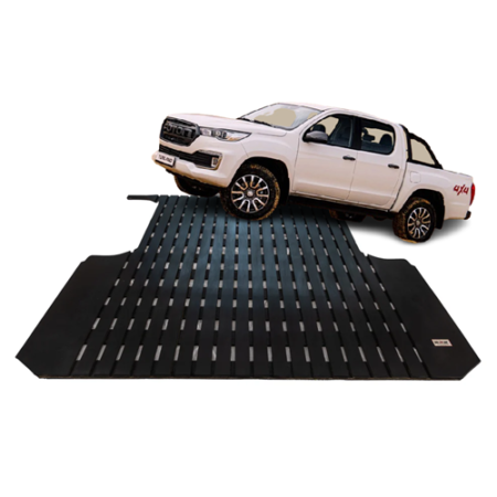 White pickup truck driving up a black grated loading ramp for vehicle loading or testing.